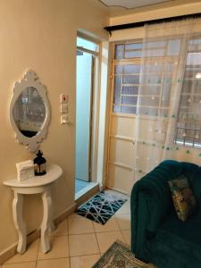 ein Badezimmer mit einem blauen Sofa und einem Spiegel in der Unterkunft Soneyhomes in Nairobi