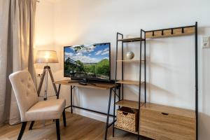 Zimmer mit einem Schreibtisch, einem TV und einem Stuhl in der Unterkunft Krause: deine Wohlfühloase in Zentrum v. Bielefeld in Bielefeld