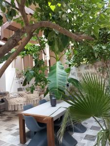 einen Tisch und Stühle in einem Innenhof mit Bäumen in der Unterkunft Casa Magnolia Patras in Patras