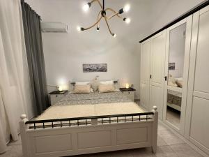 ein Schlafzimmer mit einem großen Bett und einem Kronleuchter in der Unterkunft Casa Magnolia Patras in Patras
