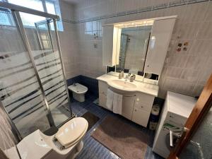 a bathroom with a toilet and a sink and a shower at Casa Magnolia Patras in Patra