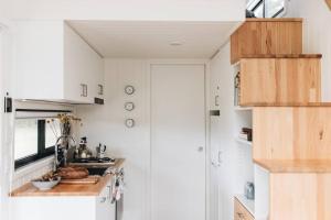 的住宿－Wildernest，厨房设有白色的墙壁和木制橱柜。