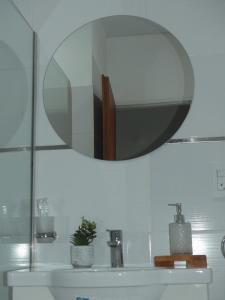 a bathroom sink with a mirror on the wall at Departamentos Fleming, luminosos p hasta 4 personas in Paraná