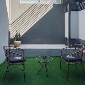 2 Stühle und ein Tisch auf einer Terrasse mit grünem Gras in der Unterkunft Departamentos Fleming, luminosos p hasta 4 personas in Paraná