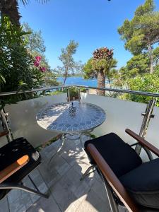 a glass table on a balcony with a view of the ocean at Apartment Stella in Mali Lošinj