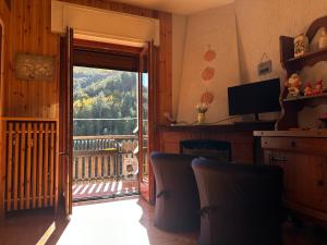 a living room with a door open to a balcony at Roccaraso Love & Lodge - Mountain Chalet in Roccaraso