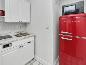 a red refrigerator in a kitchen with a microwave on top at Central Studio 17 in Miami
