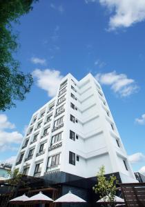 un edificio blanco con sombrillas delante en Lealea Garden Hotels - Sun Lake en Yuchi