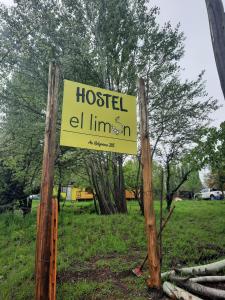 ein Schild für eine Hostelzelllinie an zwei Holzpfählen in der Unterkunft HOSTEL EL LIMON in El Bolsón