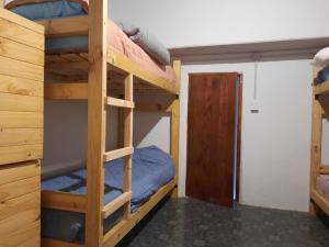 a bunk bed room with two bunk beds and a door at HOSTEL EL LIMON in El Bolsón