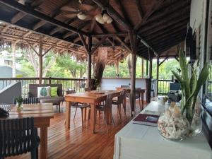 comedor con mesas y sillas y suelo de madera en Quinta Esencia en Brasilito