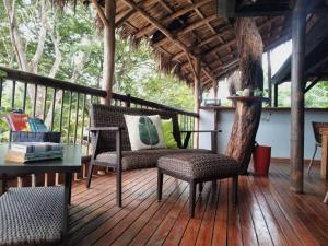 eine Veranda mit Stühlen und einem Tisch auf einer Terrasse in der Unterkunft Quinta Esencia in Brasilito