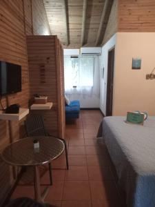 a room with a bed and a table and a tv at Quinta Esencia in Brasilito