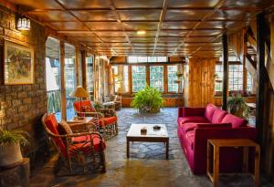 Nathia GaliGali's End By Roomy, Kalabagh Nathiagali的客厅配有紫色沙发和椅子