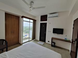 ein Schlafzimmer mit einem Bett und einem großen Fenster in der Unterkunft Hotel Sea Moon in Cox's Bazar