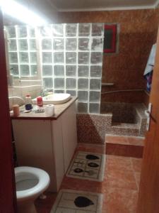 a bathroom with a toilet and a sink and a shower at La gura sobei in Mărăcineni