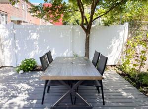 una mesa de madera y 2 sillas en el patio en New Beautiful Modern One Bedroom Apt in Brooklyn at Rem-Casa, en Brooklyn