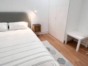 a bedroom with a bed and a white table at New Beautiful Modern One Bedroom Apt in Brooklyn at Rem-Casa in Brooklyn