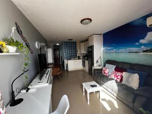een woonkamer met een bank en een keuken bij Beach Morro Jable Fuerteventura in Morro del Jable
