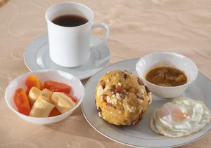 a table with two plates of food and a cup of coffee at Hotel Ebenezer in Santo Domingo de los Colorados
