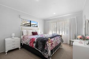 sypialnia z łóżkiem i oknem w obiekcie Bootten's Hut w mieście Rotorua