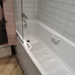 een badkamer met een douche en een wit bad bij Ratcliffe Apartment in Colchester