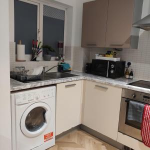 a kitchen with a washing machine and a sink at Ratcliffe Apartment in Colchester