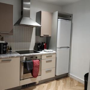 a kitchen with white cabinets and a white refrigerator at Ratcliffe Apartment in Colchester