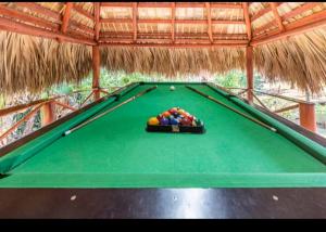 a green felt pool table with a bunch of balls on it at Villa Victoria in Sosúa