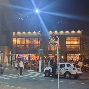 um caminhão branco estacionado em frente a um prédio em Prainha, Feirinha, Tranquilidade! na Praia Grande