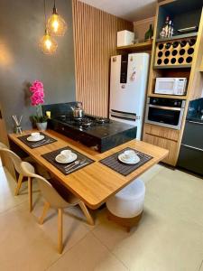 uma cozinha com uma mesa de madeira e um frigorífico em Casa aconchegante em Canela em Canela