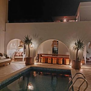a living room with a swimming pool and a house at Dar Cristina in Houmt Souk