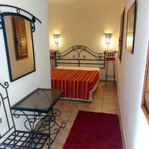 1 dormitorio con cama, espejo y silla en Dar Cristina en Houmt El Souk