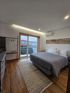 um quarto com uma cama grande e uma janela grande em ON THE WAY - Mindelo Beach/Guest House em Mindelo