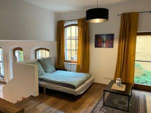 uma sala de estar com um sofá e duas janelas em Altstadt-Traum mit Fahrradstellplatz em Wasserburg am Inn