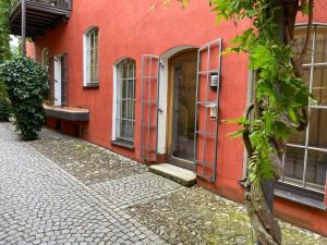 a red building with red doors on a street at Altstadt-Traum mit Fahrradstellplatz in Wasserburg am Inn