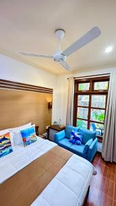 拉斯杜環礁的住宿－Beach Cottage，一间卧室配有一张大床和一张蓝色的沙发