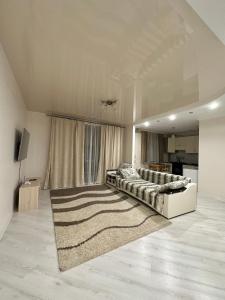 sala de estar amplia con cama y alfombra en Apartment Ivashchenka 1a en Luts'k