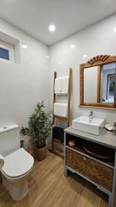 a bathroom with a toilet and a sink and a mirror at ON THE WAY - Mindelo Beach/Guest House in Mindelo