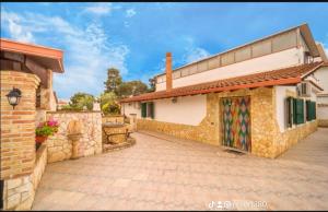 a house with a stone wall and a driveway at RESORT Valle del Re in Partinico