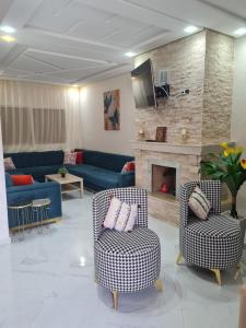 sala de estar con 2 sillas y chimenea en Villa de luxe, en Imouzzer Kandar