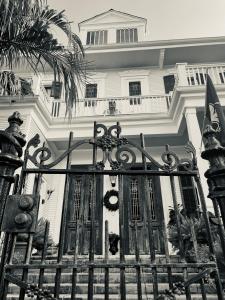 een zwart-witte foto van een huis met een hek bij The Dragonfly Guest House in New Orleans