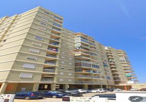 a tall apartment building with cars parked in a parking lot at Apartamento Rey I in Valencia +4 photos