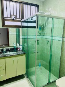 a bathroom with a glass shower and a sink at Casa Guaruja in Guarujá