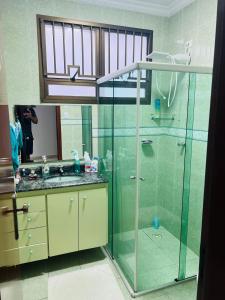 a bathroom with a glass shower and a sink at Casa Guaruja in Guarujá