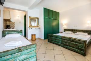 two beds in a room with green cabinets at Studios TOUTOULA in Skala Marion