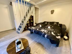 a bedroom with a bed and a table and stairs at Le P'tit Rupt Refuge cocooning in Rupt-sur-Moselle