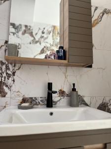 - białą umywalkę w łazience z lustrem w obiekcie Retro Apartment Patras w mieście Patras