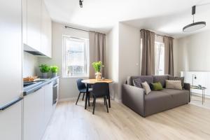 a kitchen and a living room with a couch and a table at Platinum Apartments in Warsaw