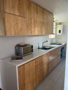 a kitchen with a sink and a microwave at Acogedor apartamento en zona corporativa Ciudad Salitre in Bogotá